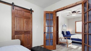 A room with a bed, a chair, and a wooden door. - Farmhouse less than a mile from beaches (Millcreek Township)