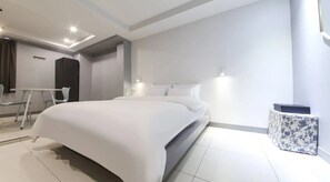 A modern hotel room with a large bed, a small desk, and a chair. - Cheongju Hotel Persona (Cheongju)