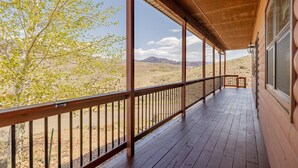 Un balcon en bois offrant une vue sur un paysage désertique.