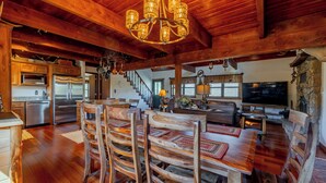 Une cuisine spacieuse avec des meubles en bois, un réfrigérateur en acier inoxydable et un lustre.