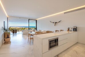 A modern kitchen with a large island, a dining area with a view, and a bull skull decoration. - New Luxury Oceanview Golf Resort, Pool and Hot-tub (San José del Cabo)