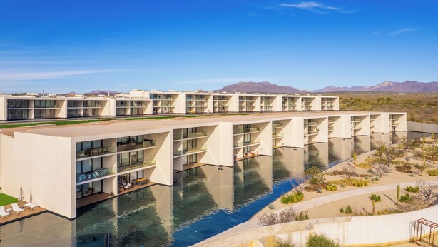 Et moderne hotel med pool og bjergudsigt.