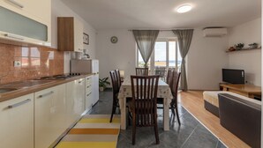 Eine moderne Küche mit Essbereich, einer Couch und einem Fernseher.