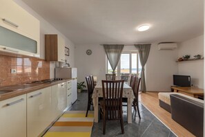 A modern kitchen with a dining area, a sofa, and a TV. - Pool Apt 1 - Novi Vinodolski (Sea View), Novi Vinodolski, Croatia (Novi Vinodolski)
