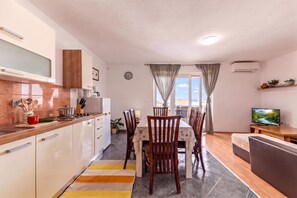 A modern kitchen with a dining area, a TV, and a view of the outdoors. - Pool Apt 1 - Novi Vinodolski (Sea View), Novi Vinodolski, Croatia (Novi Vinodolski)