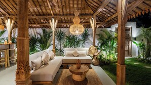 An outdoor seating area with a wooden pergola, a cushioned sofa, and a central coffee table. - Tropical escape - 4bdrs villa in Bingin Beach (Pecatu, South Kuta, Badung Regency,)