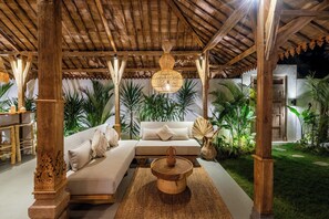 An outdoor seating area with a wooden pergola, a cushioned sofa, and a central coffee table. - Tropical escape - 4bdrs villa in Bingin Beach (Pecatu, South Kuta, Badung Regency,)