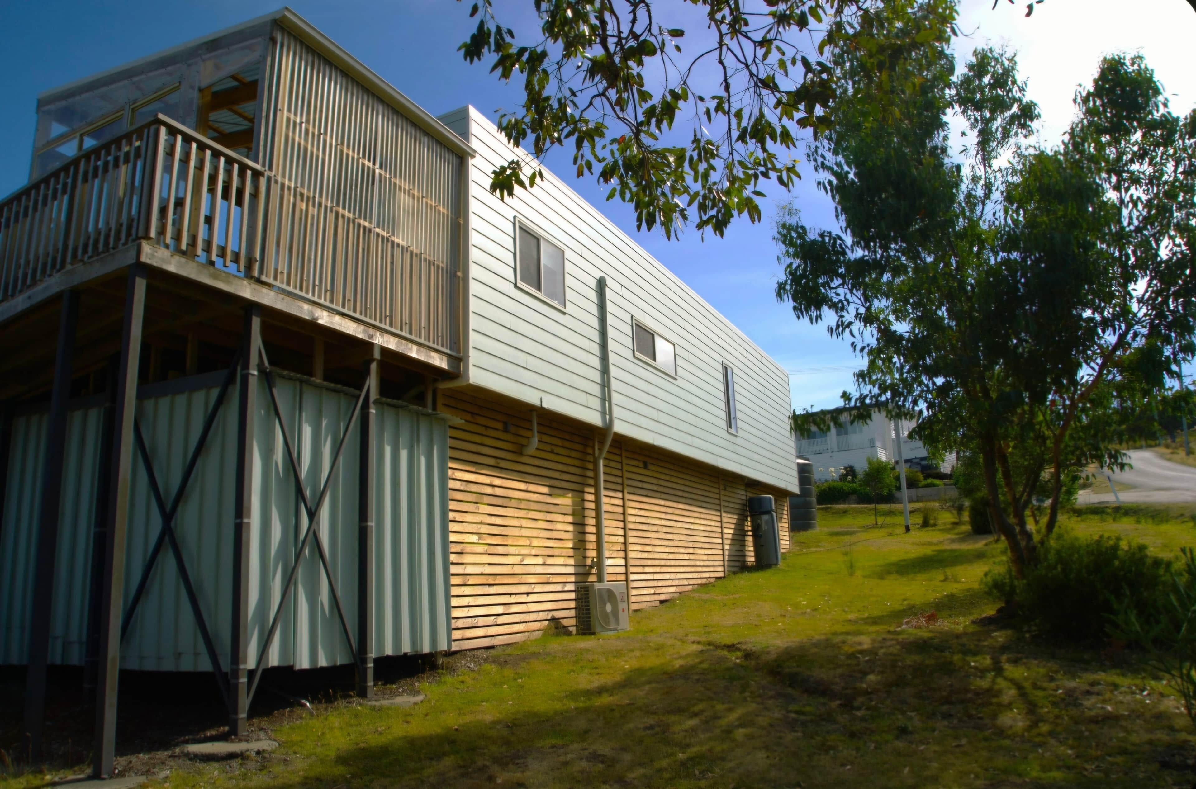 A two-story house with a balcony on the upper floor and a garage attached to the lower level.