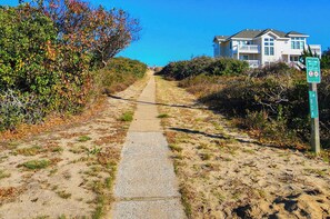 A pathway leading to a beach with a sign indicating '180 A Ocean Blvd Beach Access'. - BYUNA VISTA - 6 BR Oceanside Home w/Private Pool, Only 3 Lots from Beach Access (Southern Shores)