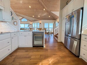 Eine moderne Küche mit weißen Schränken, einem Edelstahl-Kühlschrank und einem eingebauten Backofen.