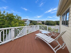 A wooden deck with white railings, a table, and two lounge chairs. - FUNNY DUCK - 4 BR Oceanside Home w/Private Pool (Duck)
