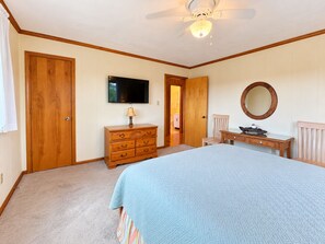 A bedroom with a bed, dresser, television, and a ceiling fan. - FUNNY DUCK - 4 BR Oceanside Home w/Private Pool (Duck)