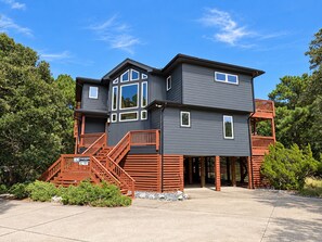 A two-story house with a balcony, a staircase, and a garage. - GONE COASTAL - 5 BR Hone in Southern Shores w/Private Pool & Hot Tub (Southern Shores)