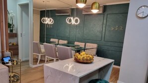 Et moderne spiseområde med en marmorø, hængende lamper og en skål med citroner.
