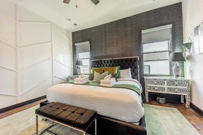 A modern bedroom with a large bed, bedside tables, and a view of the outdoors. - Boots & Broadway - 2 Units - Mins to Broadway (Nashville)