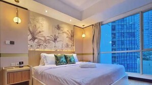 A modern bedroom with a large bed, a nightstand, a wall-mounted shelf, and a large window with a city view. - Maisón By SanLiving - 3BR - Kasablanka (Jakarta)
