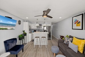 A modern kitchen with a central island, bar stools, and pendant lighting. - Florence I #203 | Updated Beachfront Condo w/ Endless Views, Pool & Hot Tub (South Padre Island)