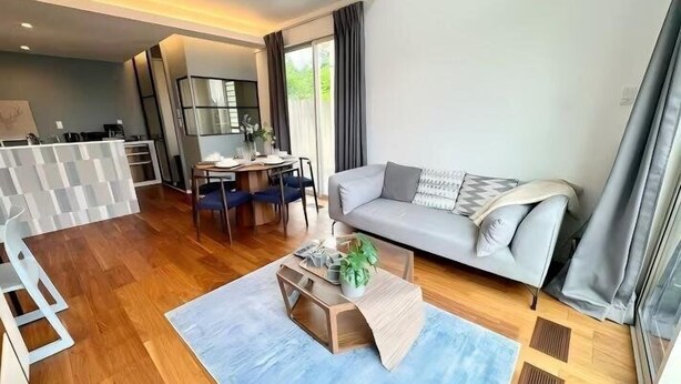 A modern living room with a sofa, coffee table, and dining area.