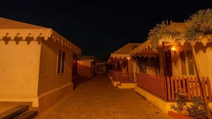 A corridor with traditional architecture, narrow pathway, and warm lighting. - Aureva Raj Bagh Retreat (Jaipur)