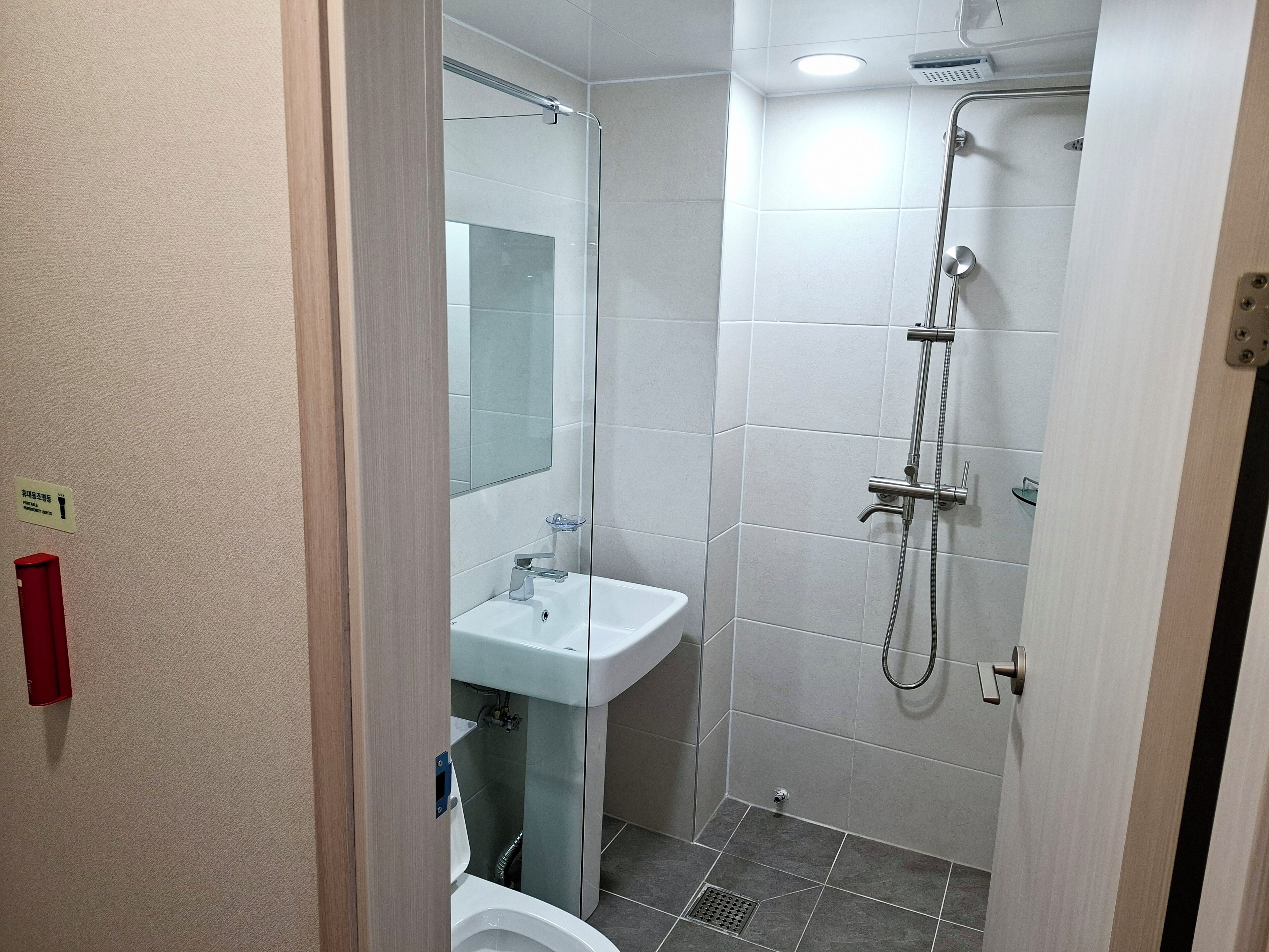 A bathroom with a shower, sink, and toilet.