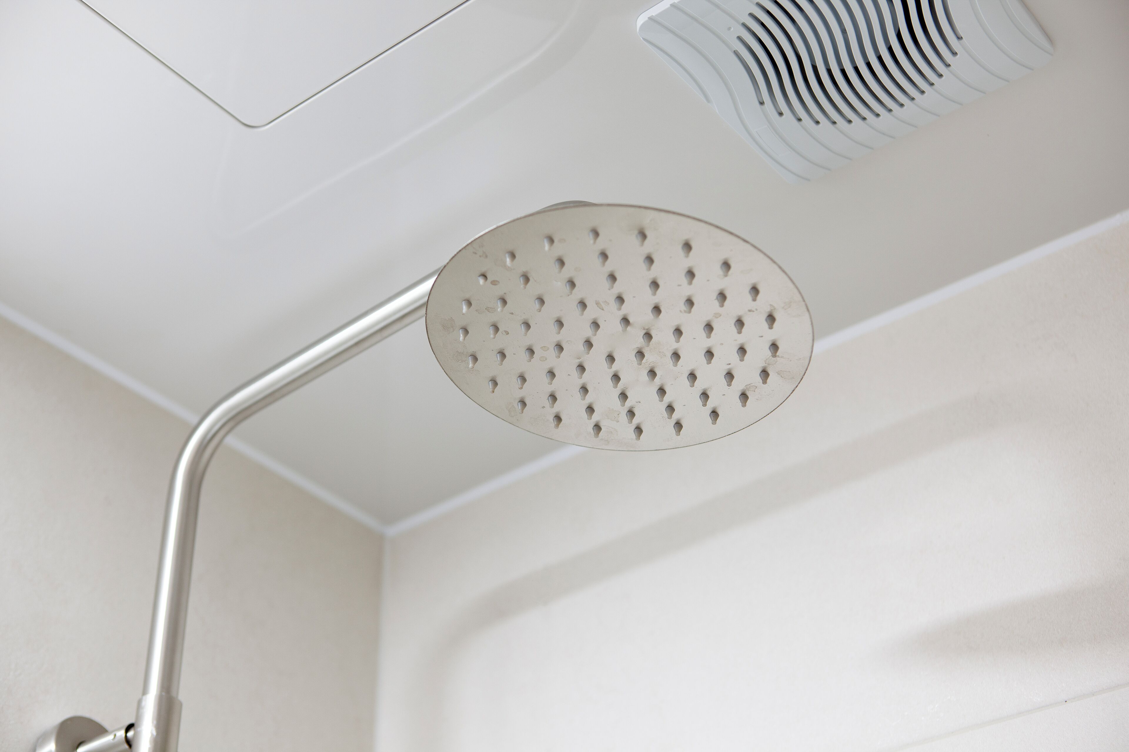 A showerhead with a curved handle and a circular design.