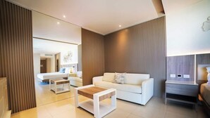 A modern living room with a white sofa, a wooden coffee table, and a nightstand.