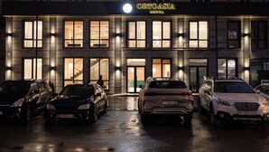 A hotel with a modern facade, multiple parking spaces, and illuminated windows. - Hotel Orto Asia (Bishkek)