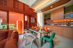 A modern kitchen with wooden cabinets, a built-in oven, and a countertop with a fruit bowl. - Kana Casa Canggu by Nagisa Bali (Canggu)