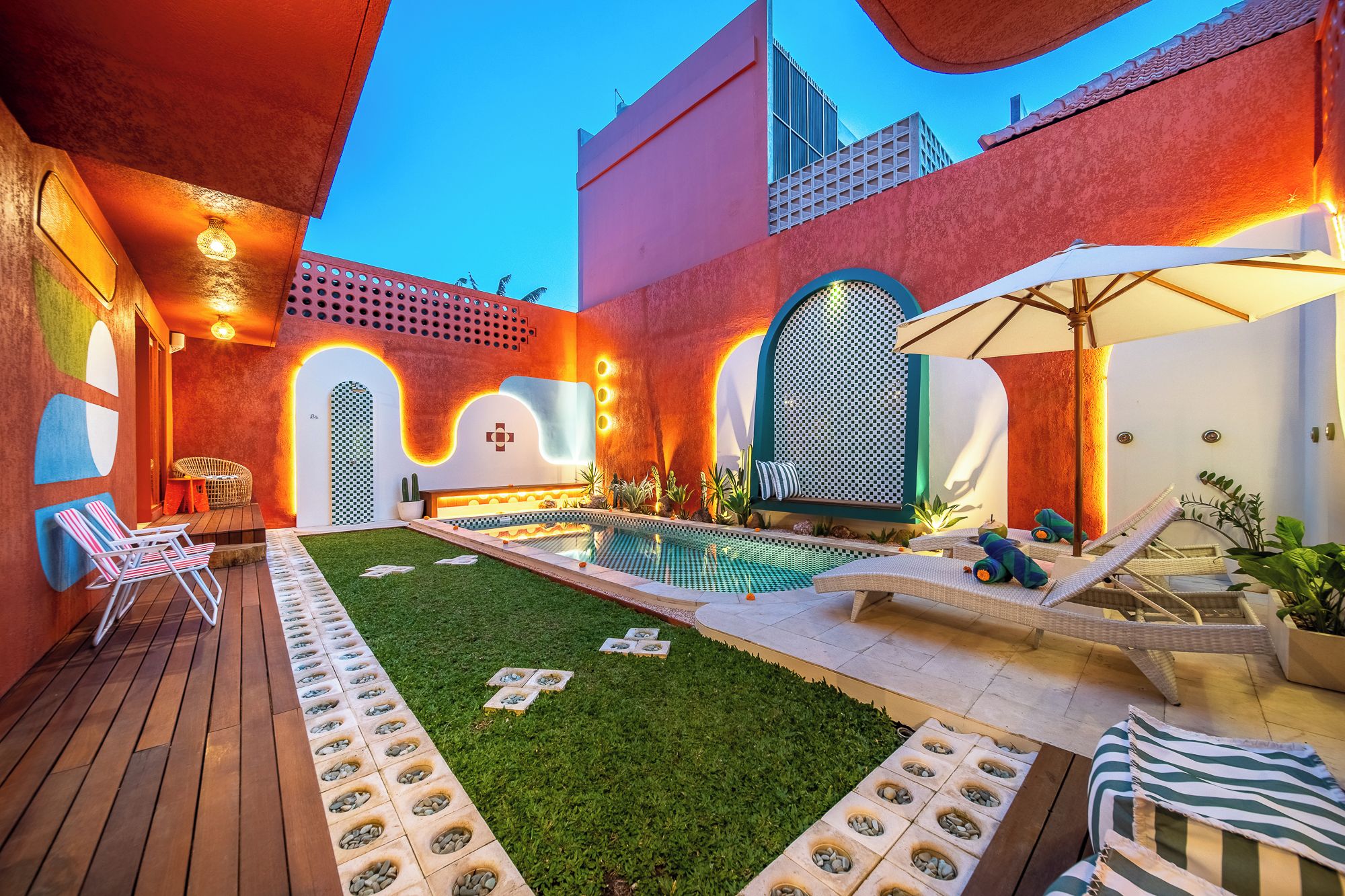 A rooftop pool area with lounge chairs, a small pool, and a pergola.