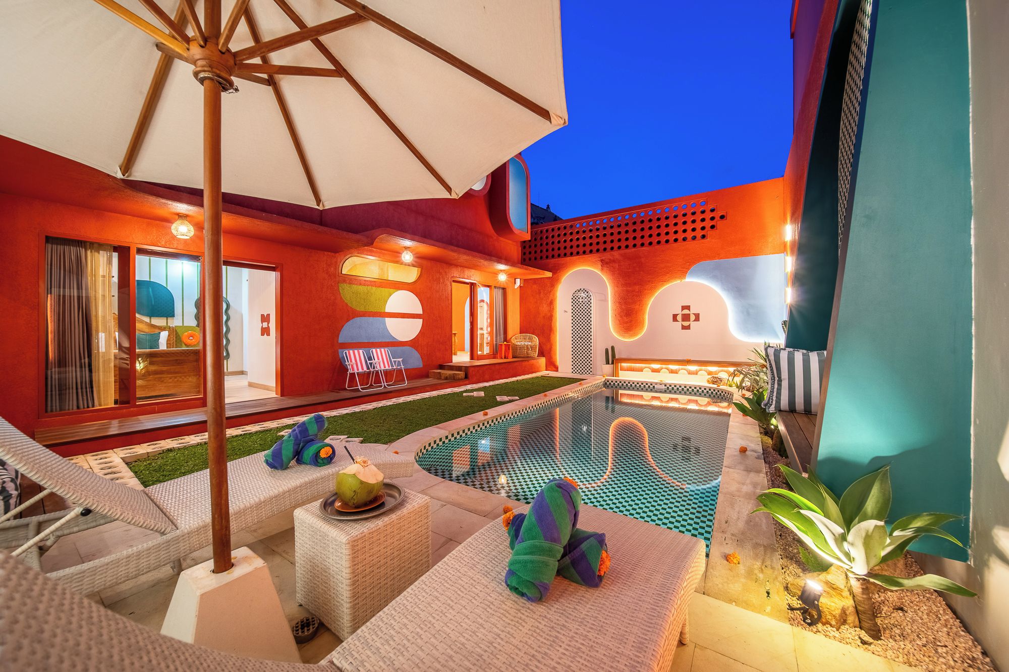 Un espace aménagé au bord de la piscine, avec des chaises longues, une petite piscine et un espace extérieur bien éclairé.