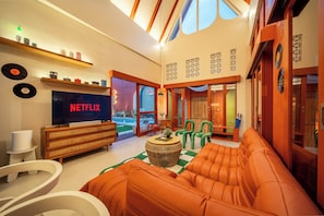 A modern living room with a flat-screen TV, a sofa, and a coffee table. - Kana Casa Canggu by Nagisa Bali (Canggu)