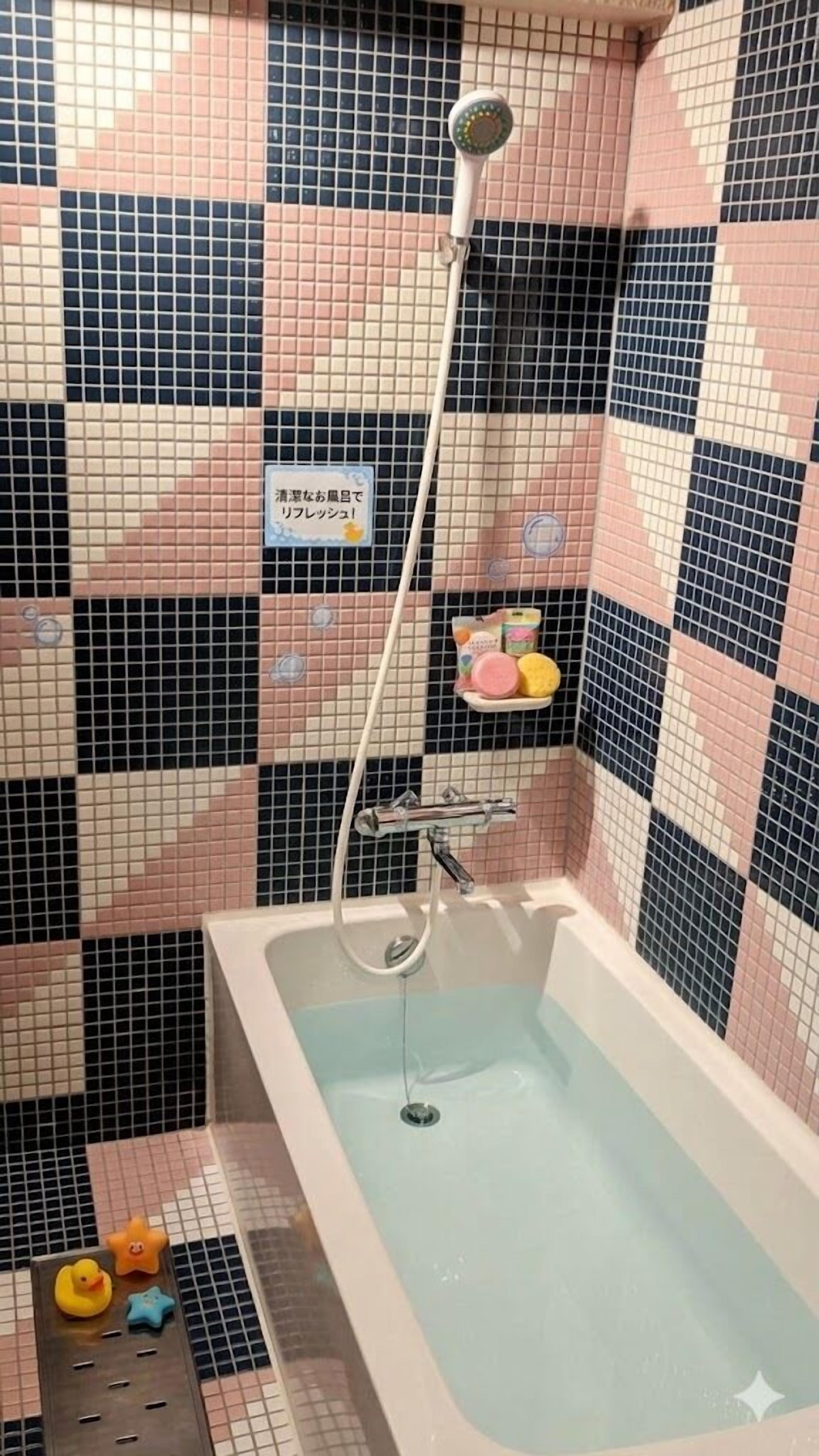 Bañera con ducha, toallas, jabón, shampoo