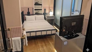 A hotel room with a bed, bedside table, TV, and a window. - HOTEL CANDY BOX (Osaka)