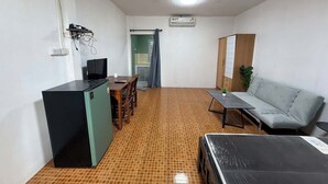 Um espaço compacto para viver, com cozinha compacta, sofá, mesa de jantar e televisão.