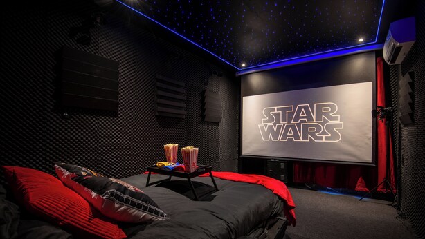 A Star Wars-themed room with a large screen, popcorn, and a bed with red bedding. - Cinéma Provence - Air-conditioned - 7ᵉ art (Avignon)