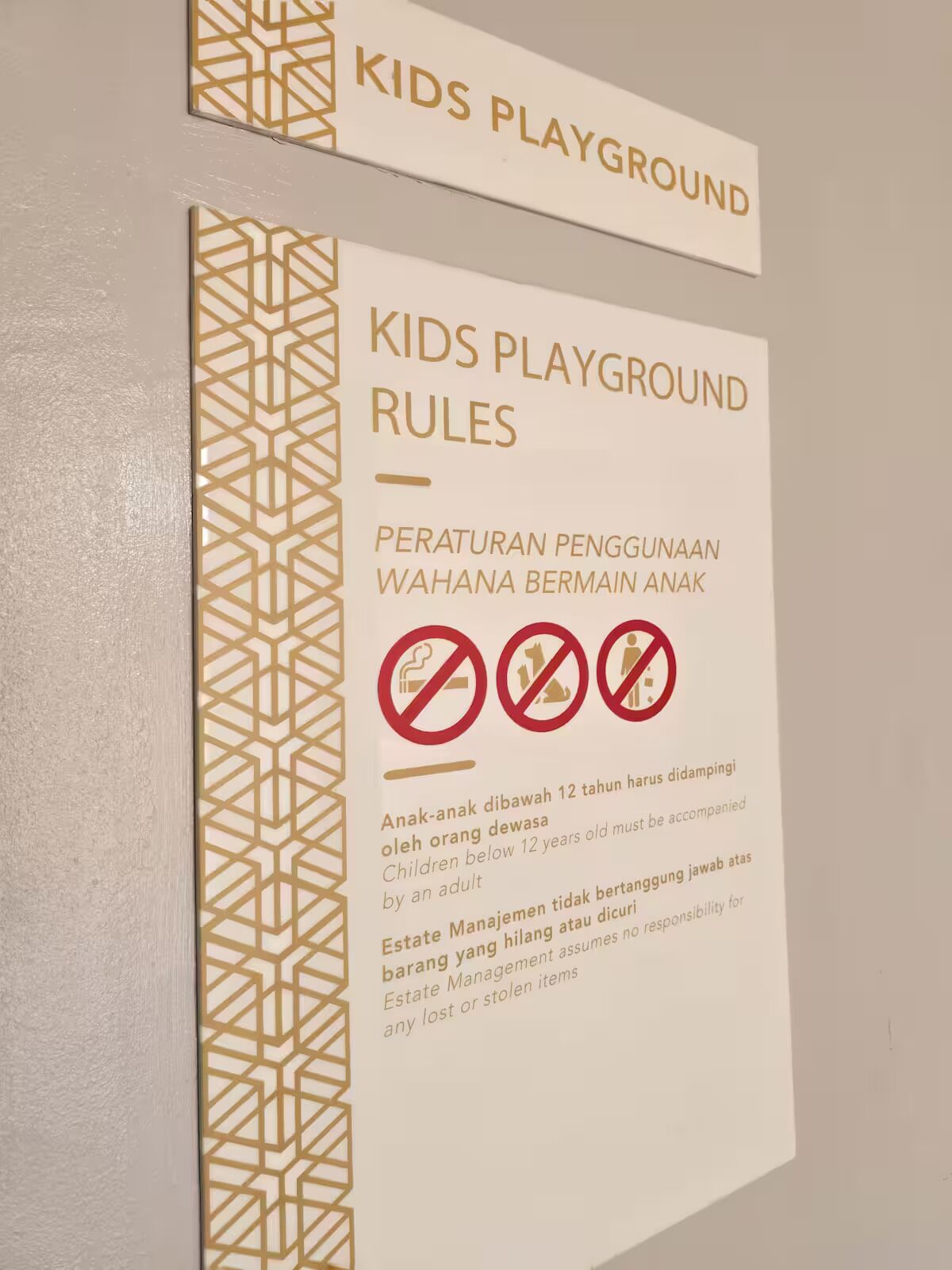 A sign with rules for a kids' playground, including age restrictions and prohibitions.