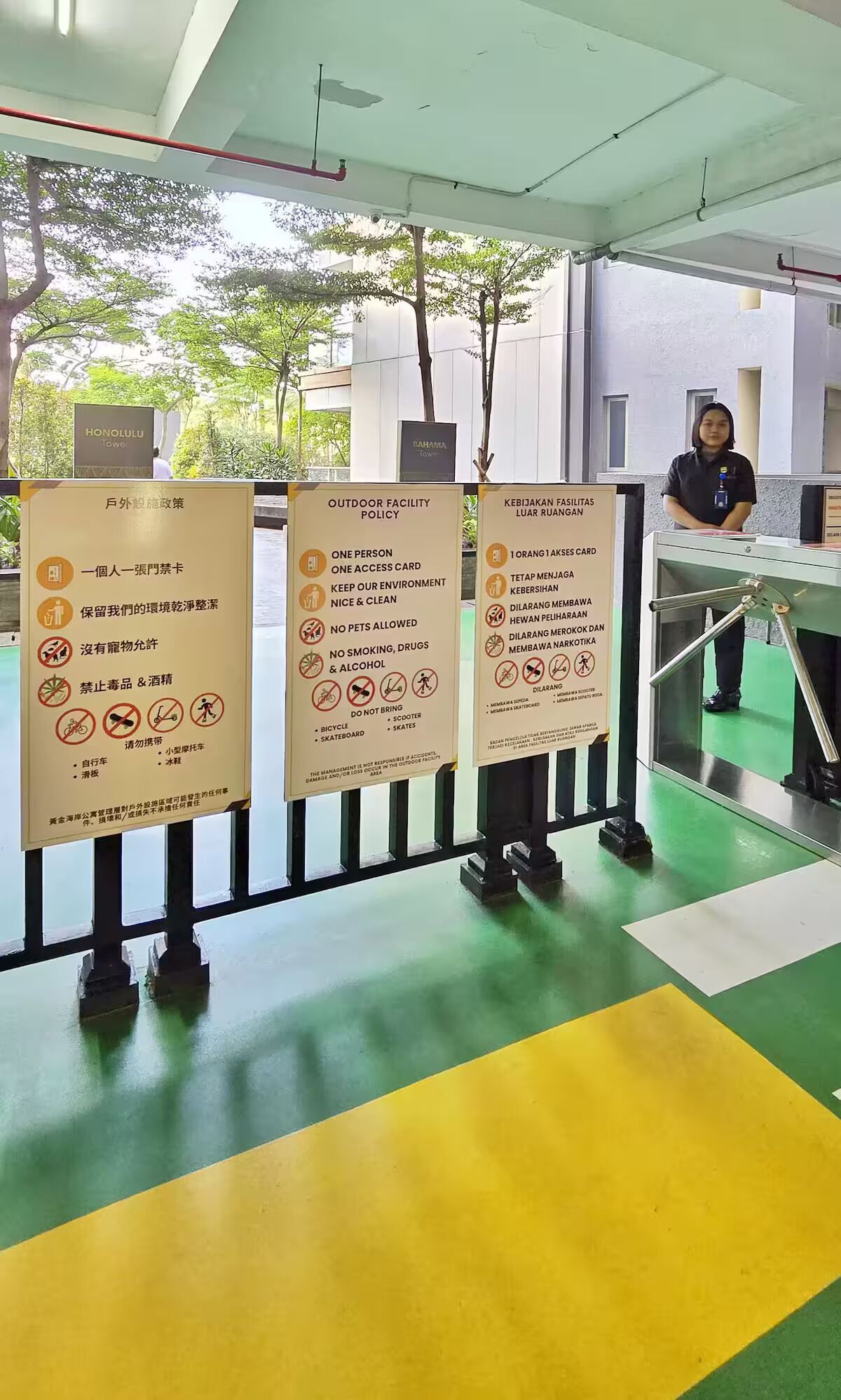 A person standing behind a counter with three informational signs in front of them.