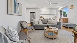 Ein modernes Wohnzimmer mit einem grauen Sofa, einem Couchtisch und einem Gemälde an der Wand.