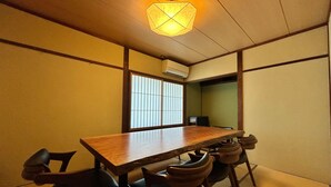 Una habitación de estilo japonés tradicional con suelo de tatami, una mesa de madera y cuatro sillas.