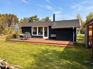 A house with a deck, a barbecue area, and a chimney. - Lovely holiday home with garden near water (Rødby)