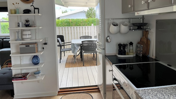 Une cuisine équipée d’un fourneau, de placards et d’un coin repas avec une table et des chaises.