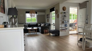 Un salon moderne avec un canapé, une table basse ronde et un coin repas comprenant une chaise.