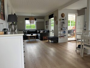 Un salon moderne avec un canapé, une table basse ronde et un coin repas comprenant une chaise.