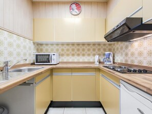 A compact kitchen with a microwave, coffee maker, and gas stove. - Pretty apartment on the casino (Blankenberge)