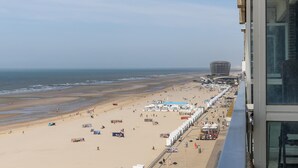 Ein Strand mit einer Promenade, einem großen Stadion und einem Gebäude mit einem einzigartigen, kugelförmigen Design.