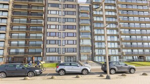 A multi-story residential building with balconies and large windows. - Cosy studio with sleeping area and sea view (Middelkerke)
