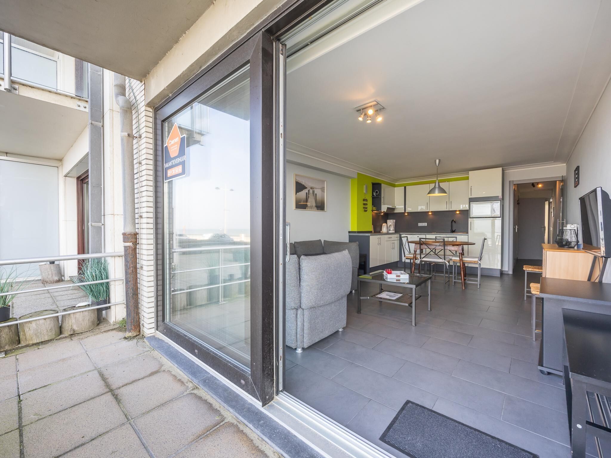 A modern apartment with a balcony, a dining area, a kitchen, and a living room.