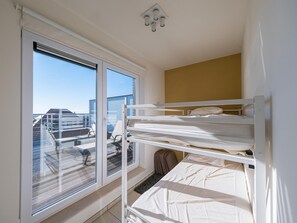 A bunk bed room with a large window, a view of the cityscape, and a ceiling light fixture. - Exclusive penthouse with 2 sunny terraces (Middelkerke)