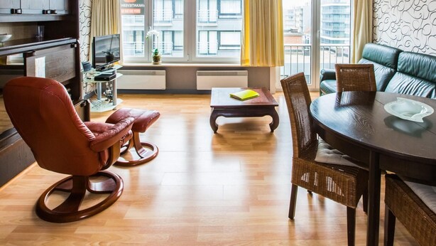 A modern living room with a dining area, a sofa, and a TV. - Apartment on the 6th floor with sea view (Middelkerke)