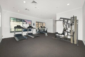 Ein Fitnessraum mit Laufbändern, einem Hometrainer und Kraftgeräten.